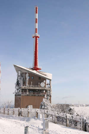Telecommunication tower on top of mountain frozen in cold winter morningの写真素材
