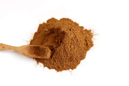 Cinnamon powder on white background with woode spoonの写真素材