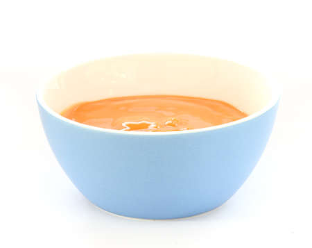 Close up view of baby orange fruit porridge / mush in blue bowlの写真素材