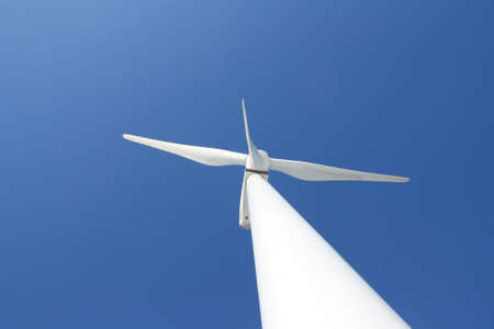 View of single windmill generating electricity against blue sky