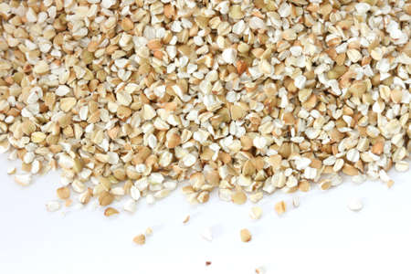 Scattered view of dry raw pealed buckwheat on white backgroundの写真素材