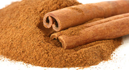 Whole cinnamon sticks on heap of ground cinnamonの写真素材