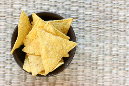 Mexican tortilla chips in brown bowl on white backgroundの写真素材