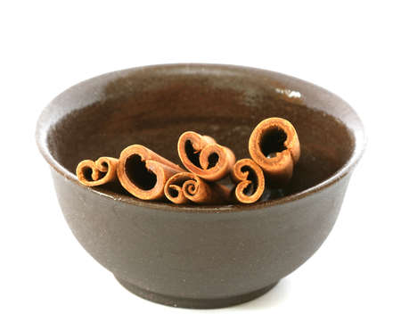 Whole cinnamon sticks in brown bowlの写真素材
