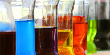 Row of glasses with colorful liquids - detail view