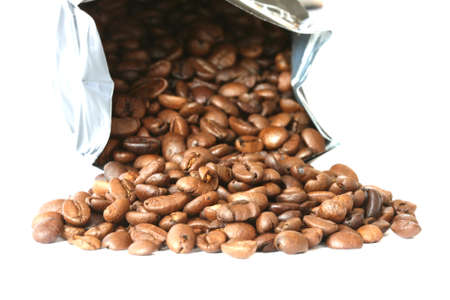 Whole coffee beans scattered and bag on white backgroundの写真素材