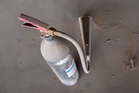 rusty and dusty fire extinguisher, red handle