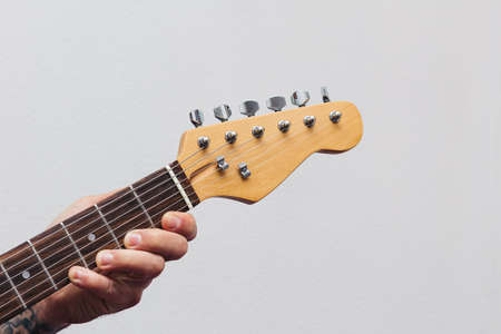 Music teacher hand playing electric guitar. electric bass. white background with copy space. pop,...