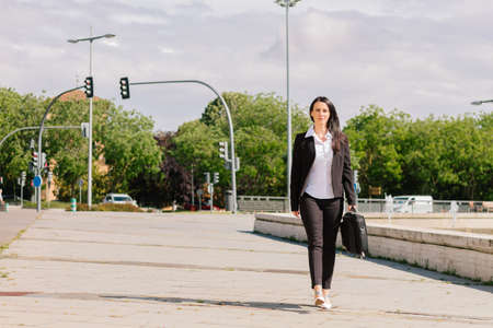 Young adult attractive businesswoman walking down a city street on her way to work.の写真素材