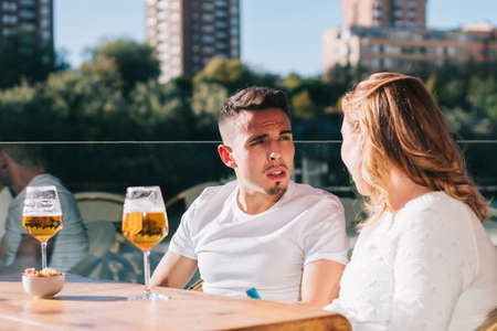 Friends drinking a beer while having a meeting with friends at the bar or restaurant.