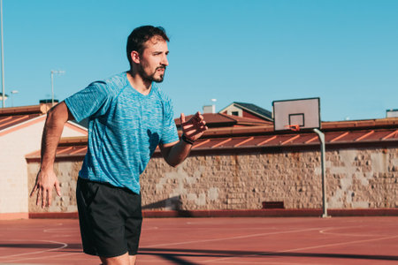 Running athlete man. Male runner running during outdoor training for marathon. Athletic young sport fitness model in his 30s outdoors in nature.の写真素材