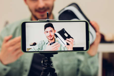 Close-up of a blogger's mobile phone while recording content for his channel. Vlogger man making a...