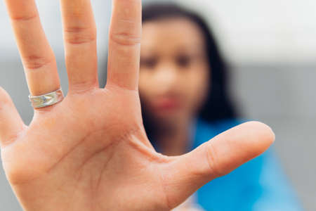 Close-up of a woman's palm, makes the hand stop the denial gesture, expresses prohibition, rejection, fights for equal rights against domestic violence, abuse, discrimination, harassmentの写真素材