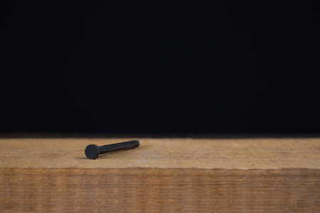 Hammer with nail on black backgroundの写真素材