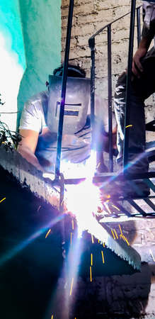 Worker welding metal stair steps