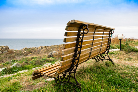 Wooden bench in front of the sea. Beautiful Bench with sea in the backgroundの写真素材