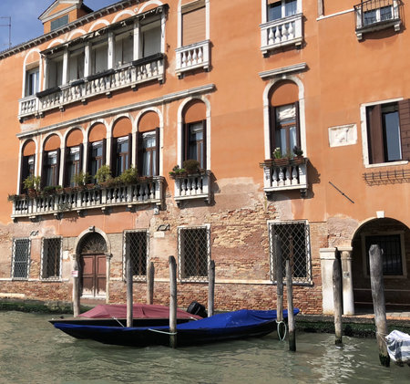 A pier on the Grand Canal in Venice. In the background the typical orange facades of Venetian architecture.の写真素材