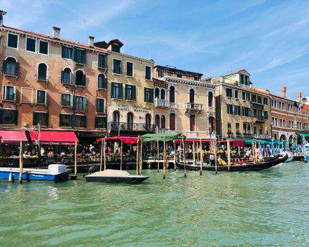 Gondolas and restaurants located on the Grand Canal in Venice. Italy In the background, the characteristic constructions of Venetian architecture.の写真素材
