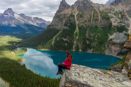 Hiker woman on top of Opabin Prospect overlooking Lake O'Hara and Mary Lake with the Canadian Rockies in the background. British Columbia, Canadaのeditorial素材