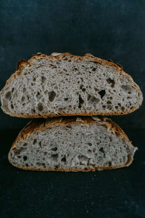 Close up or detailed view of freshly baked sourdough bread, dark background.の写真素材