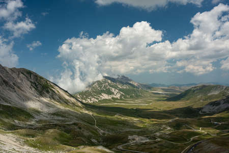 Mountains and valley, blue sky and cloudsの写真素材