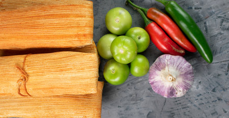 Mexican cuisine, meat tamales accompanied by garlic, chili and tomatoの写真素材