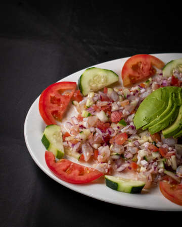 Mexican food. Fish and shrimp ceviche dish with avocado, tomato and onion,の写真素材