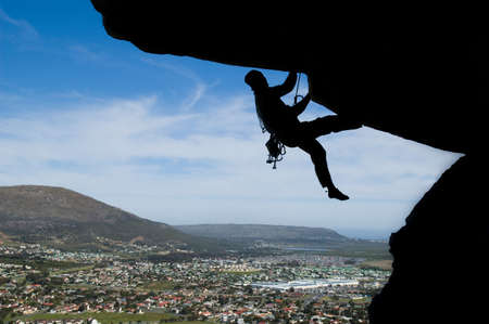 Silhouette of a rock climber with sunset clouds in the backgroundの写真素材