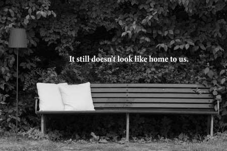 Homeless man on a park bench with a carboard signの写真素材