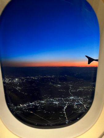 View from airplane window at night with cityscape in the background.の写真素材