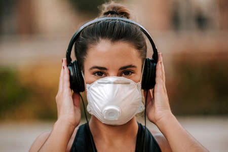 girl does sports with a mask on the street during the quarantine of coronavirusの写真素材