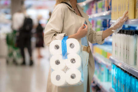 girl in the supermarket with toilet paper during the coronavirus quarantineの写真素材