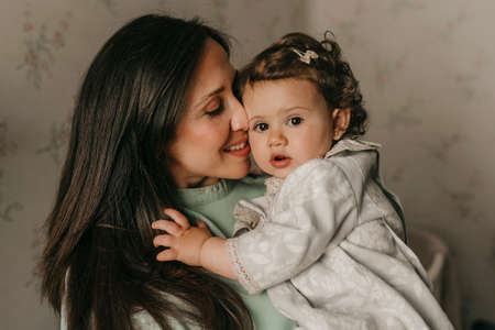 pretty young mother with her little daughter in a room at home having funの写真素材