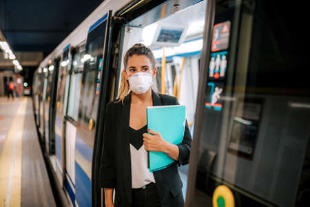 young woman with medical mask leaving the subwayの写真素材