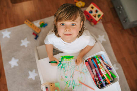 Little blond boy plays painting at home. entertainment during quarantine. family at home coronavirus.の写真素材