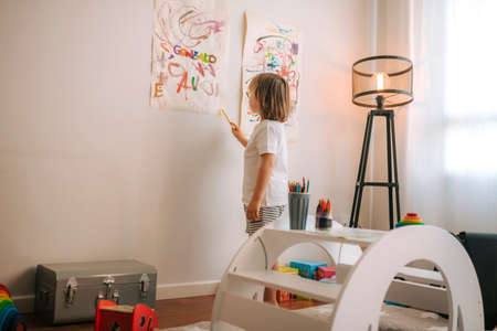 Little blond boy plays painting at home. entertainment during quarantine. family at home coronavirus.の写真素材