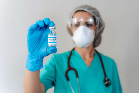 COVID-19 Coronavirus Vaccine. Doctor scientist analyzing virus Sars-CoV-2 in research for vaccine to...