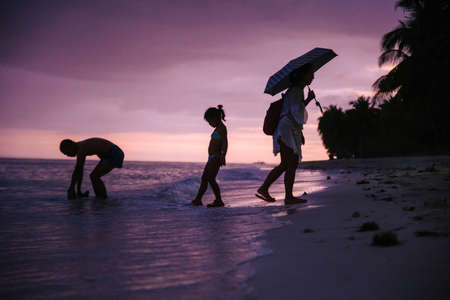 people enjoy the last hours of sunset on a coast of the philippinesの写真素材