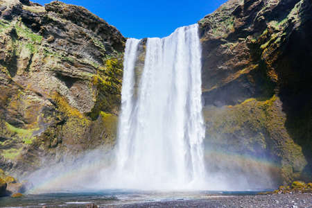 A waterfall with a rainbox in Iceland.の写真素材