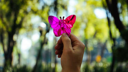 A close-up of a purple plastic butterfly. It's can't fly away because it isn't real.の写真素材