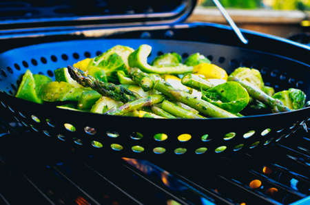 A grill pan with asparagus, zucchini, brussel sprouts and more.