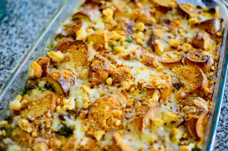 Eggs, bagles and cheese baked in a glass dish cooling on the counter.