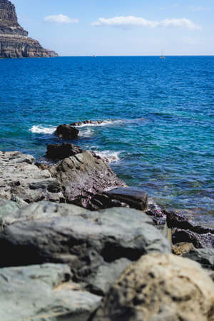 Beach with rocks in the foreground and no wavesの写真素材