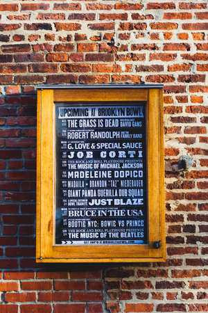 Concert sign against a brick wall