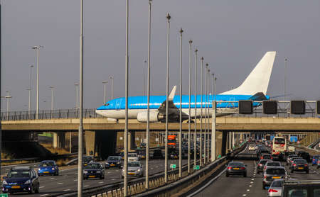 Airplane taxing over eight lane highwayのeditorial素材