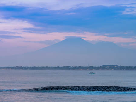 Setting Sun in Kuta with Volcano seen in distanceの写真素材