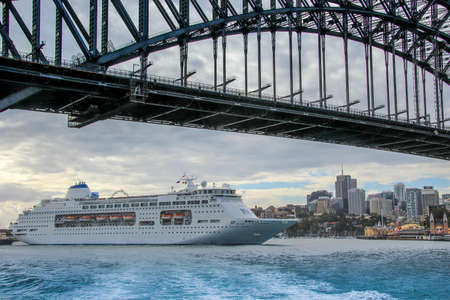 AUSTRALIA, SYDNEY - MARCH 21, 2014: Large cruise ship just fitting under the Sydney Harbour Bridgeのeditorial素材