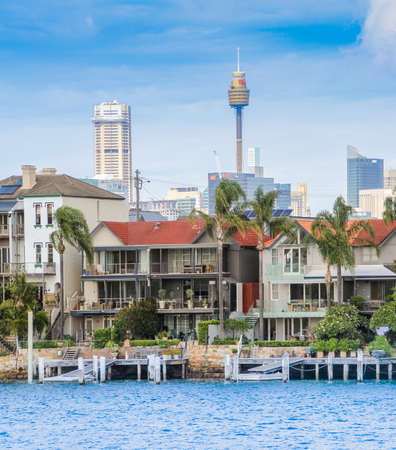 AUSTRALIA, SYDNEY - MARCH 21, 2014: Sydney Harbour water front houses wih city skyline behindのeditorial素材