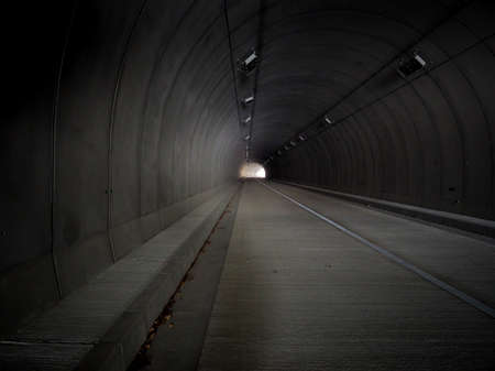 Empty road tunnel with light at the end of it.の写真素材