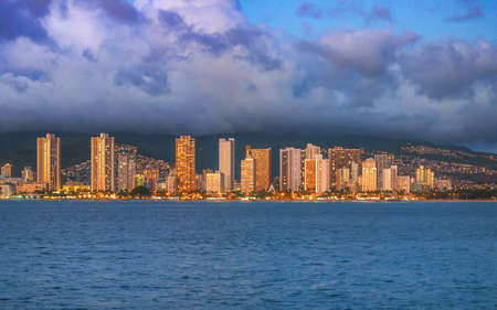 Buildings of downtown Honolulu light up during sunset.の写真素材